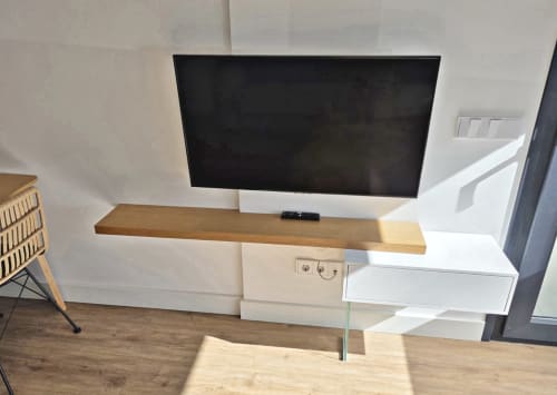 Televisor moderno montado en pared con repisa de madera y unidad de almacenamiento blanca en apartamento de Sanxenxo, hotel BR SILGAR