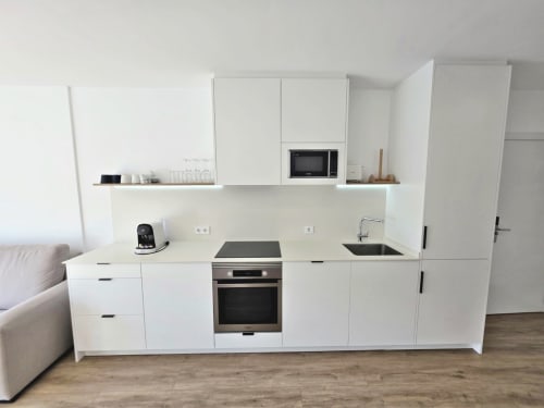 Cocina moderna blanca en apartamento BR Silgar, Sanxenxo con electrodomésticos de acero inoxidable y almacenamiento