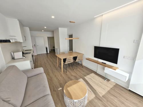 Apartamento moderno en BR Silgar Sanxenxo con sala abierta, cocina, comedor y zona de entretenimiento con TV