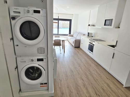 Cocina moderna con lavadoras y secadoras Whirlpool apiladas en apartamento BR SILGAR, Sanxenxo, España