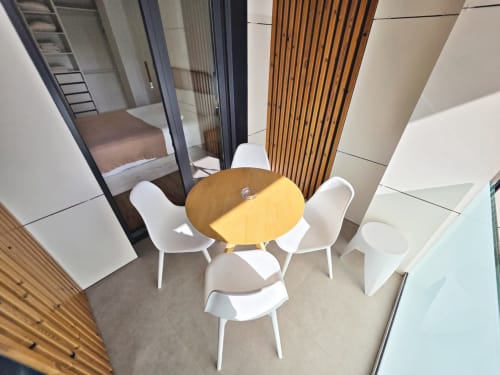 Comedor moderno en apartamento BR SILGAR, Sanxenxo, con mesa redonda de madera y sillas blancas