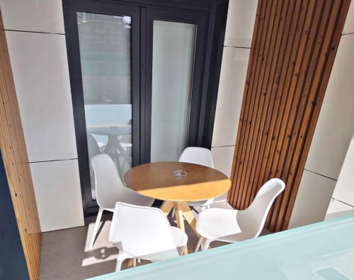Terraza del apartamento BR SILGAR en Sanxenxo con mesa redonda de madera, sillas blancas y puertas de cristal