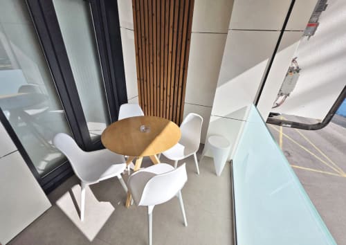 Terraza moderna del apartamento BR Silgar Sanxenxo con mesa redonda de madera, sillas blancas y vistas al mar