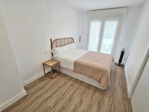 Habitación luminosa en BR Silgar Sanxenxo con cama queen, mesita de noche de madera y puertas al balcón