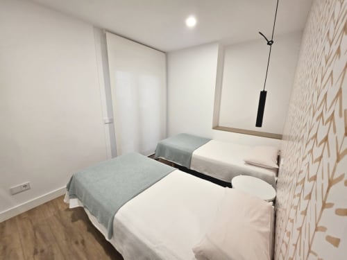 Dormitorio doble en apartamento BR SILGAR en Sanxenxo con dos camas individuales, suelo de madera y decoración moderna