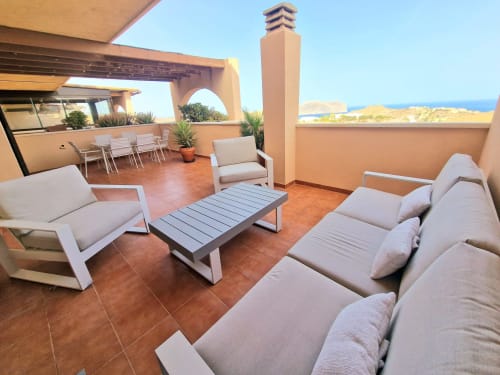 Terraza en la azotea de ATTC International vacaciones en Águilas con vistas al mar, asientos cómodos y mobiliario moderno