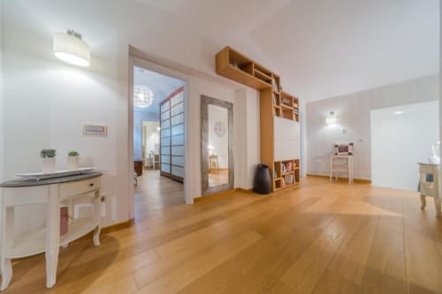 Ampia camera padronale a Country Domos con pavimenti in legno, scaffali in legno, arredi moderni e vista sul giardino a Ozieri