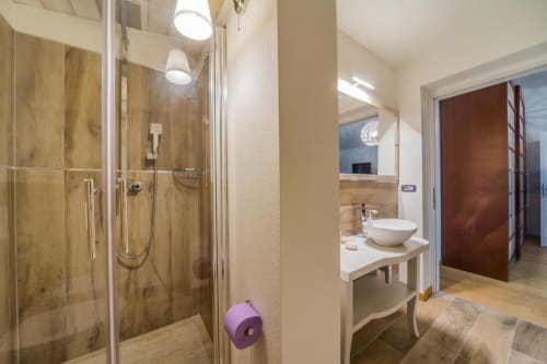Bagno padronale moderno a Country Domos B&B a Ozieri con doccia walk-in, lavabo design e pavimenti in legno