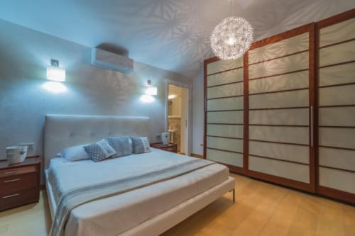 Camera da letto moderna presso Country Domos B&B a Ozieri con letto queen, armadio in legno e illuminazione contemporanea