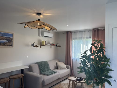 Intérieur cottage moderne à la Résidence Les 3 Volcans à Clermont-Ferrand avec canapé gris, luminaire suspendu et vue sur le jardin
