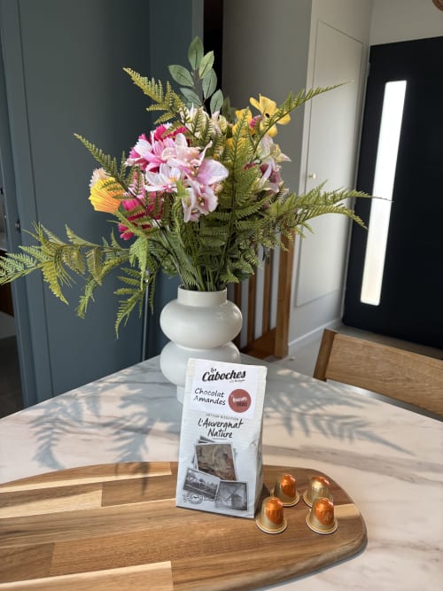Bienvenue à la Résidence Les 3 Volcans Clermont-Ferrand : fleurs, chocolats et capsules de café sur bois