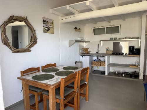 Cuisine et salle à manger de la villa à la Residence Fium Del Cavo à Zonza avec table en bois, kitchenette et décoration côtière