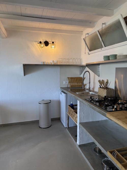 Cuisine moderne de la villa avec cuisinière à gaz, évier, égouttoir et rangements à la Résidence Fium Del Cavo, Zonza