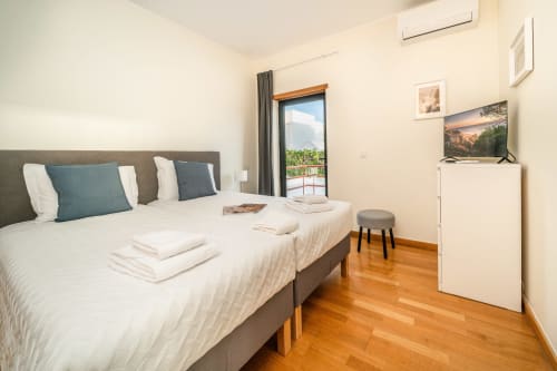 Quarto moderno da Villa Odyssey, Albufeira com cama de casal, varanda com vista para o mar e piso em madeira