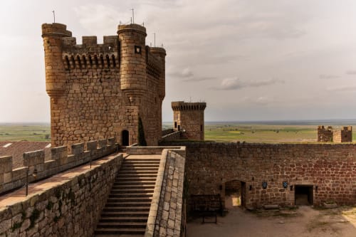 Fortaleza medieval con torres de piedra con vistas a las llanuras verdes en Casa Rural El Infante, Oropesa, España