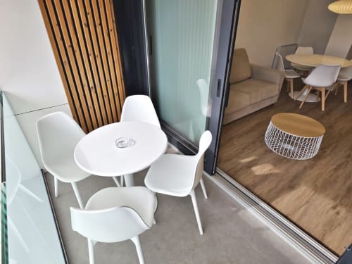 Moderna zona de estar en la terraza del apartamento BR Silgar Sanxenxo con mesa blanca, sillas y vistas al océano
