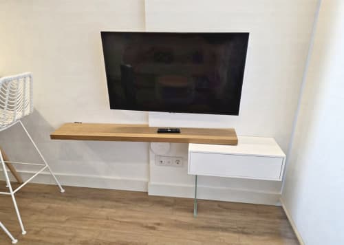 Moderno salón de entretenimiento en BR Silgar Sanxenxo con televisor de pared, estantería de madera y armario blanco