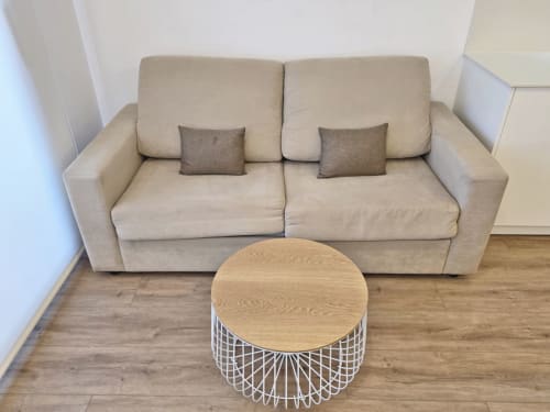 Sofá beige con cojines decorativos y mesa redonda de madera en apartamento BR SILGAR, Sanxenxo