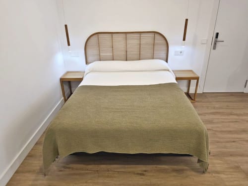 Dormitorio moderno en BR Silgar Sanxenxo con cama de ratán, almohadas blancas, manta verde oliva y mesitas