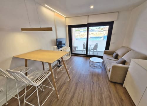 Apartamento moderno en BR SILGAR Sanxenxo con comedor, sofá y terraza con vistas a la costa