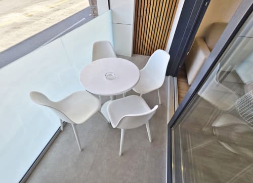 Mesa redonda blanca moderna con cuatro sillas en terraza del apartamento BR Silgar en Sanxenxo, España