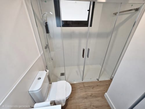 Cuarto de baño moderno con inodoro, mampara de ducha cristal y suelos con efecto madera en el apartamento BR SILGAR de Sanxenxo