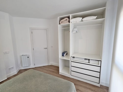 Armario moderno de dormitorio con cajones y estanterías en el apartamento BR SILGAR de Sanxenxo, España