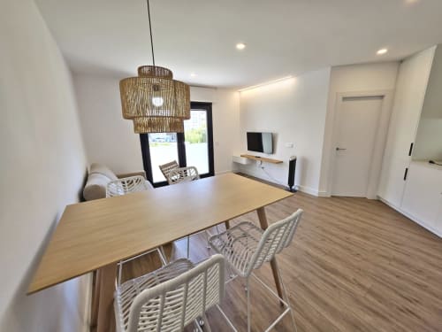Comedor moderno en BR SILGAR, Sanxenxo con mesa de madera, lámpara colgante de mimbre y TV en la sala de estar