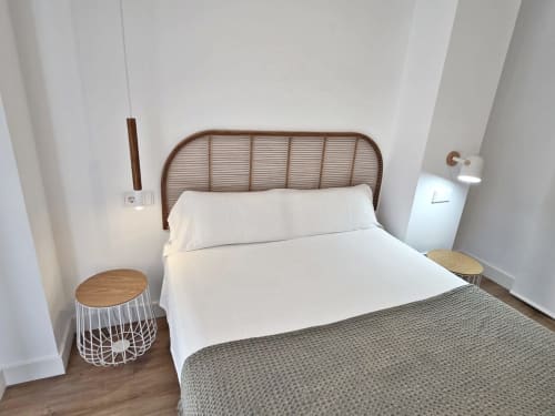 Dormitorio minimalista en BR Silgar Sanxenxo con cabecero de ratán, ropa de cama blanca, mesitas de madera y alfombra texturizada