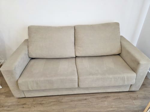 Sofá de dos plazas color beige en apartamento de Sanxenxo Silgar, suelo de madera, paredes blancas