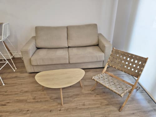Sofá beige con mesa de café de madera y silla tejida en la sala de estar del apartamento Sanxenxo Silgar