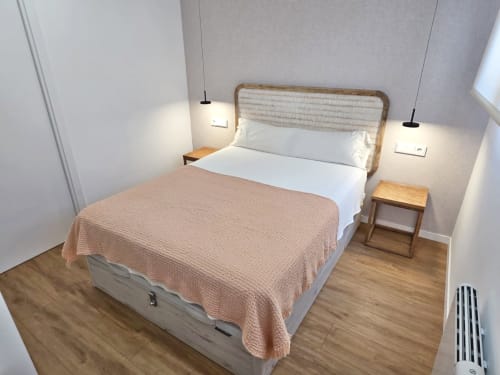 Habitación moderna en BR Silgar Club 2, Sanxenxo: cama Queen, cabecero tejido, luminarias colgantes y mesillas de madera