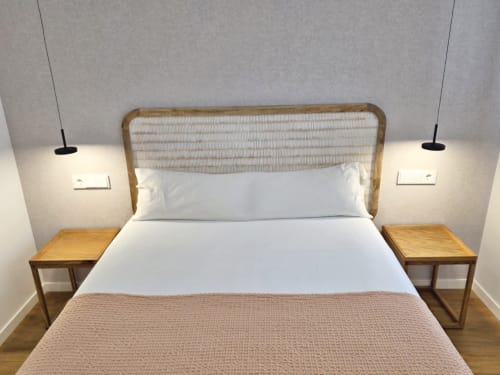 Dormitorio moderno en apartamento BR Silgar Club 2 de Sanxenxo con cabecero de ratán, ropa de cama blanca, mesitas de noche de madera y