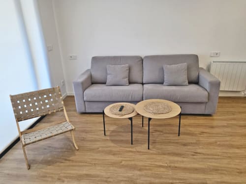 Sala de estar del apartamento BR Silgar Club con sofá gris, mesas laterales tejidas y silla de madera en Sanxenxo