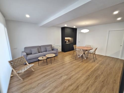 Sala de estar del apartamento BR Silgar Club 2 en Sanxenxo con sofá gris, zona de comedor e iluminación moderna