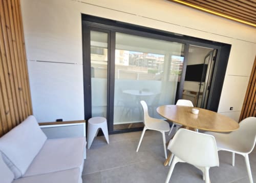 Salón moderno del BR Silgar Club, Sanxenxo con mesa de comedor, sillas blancas, sofá y acceso a terraza