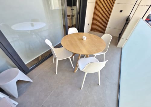 Comedor del apartamento BR Silgar Club con mesa redonda de madera y sillas blancas en Sanxenxo