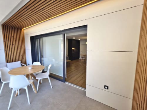 Sala de estar del apartamento BR Silgar Club en Sanxenxo con mesa de comedor, sillas blancas y diseño interior moderno