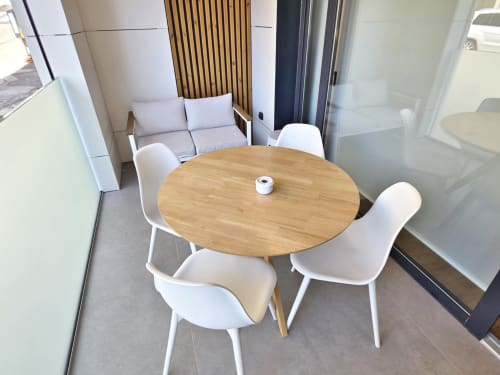 Comedor moderno en apartamento BR Silgar Club 2, Sanxenxo con mesa redonda de madera y sillas blancas