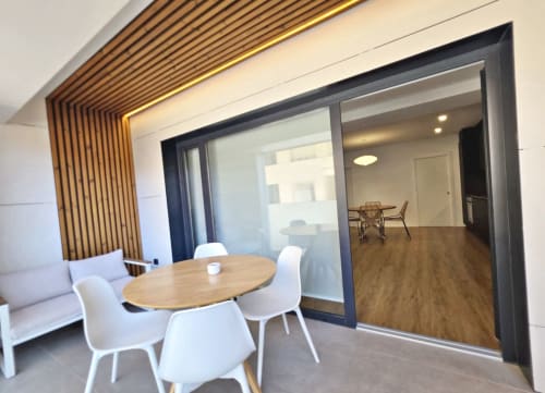 Apartamento BR Silgar Club 2 en Sanxenxo con zona de comedor, sillas modernas, mesa de madera y sala de estar abierta