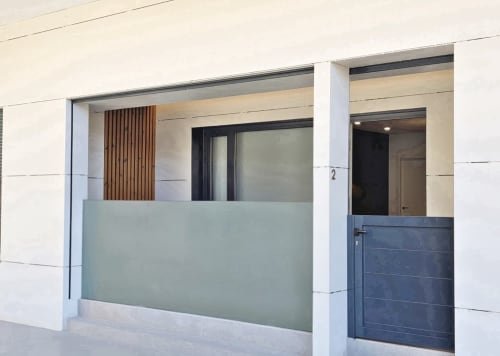 Entrada del apartamento BR Silgar Club 2 en Sanxenxo con fachada moderna y escaparate de vidrio esmerilado