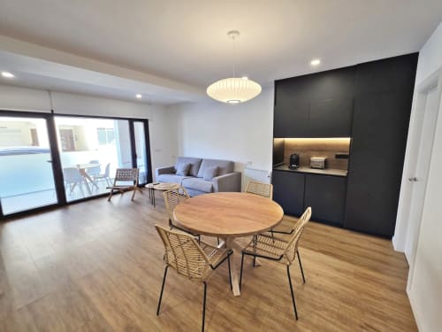 Apartamento BR Silgar Club 2 en Sanxenxo: espacio moderno con mesa de comedor, sofá y cocina con muebles negros