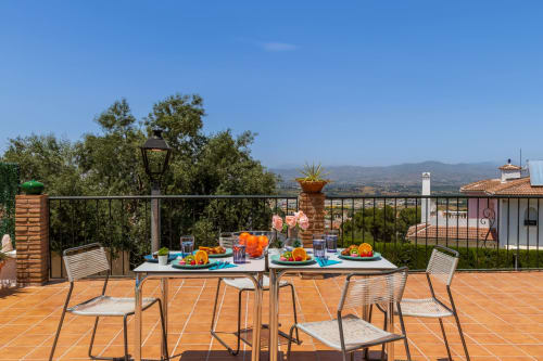 Terrace dining setup at Ayma Casa Nísperos in Alhaurín de la Torre with countryside views and outdoor seating