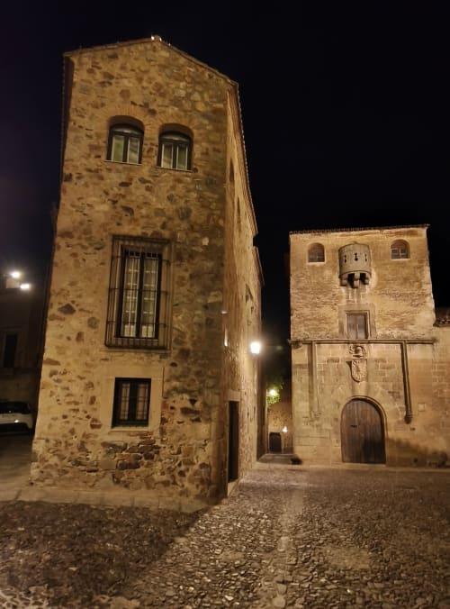 Torres medievales de piedra por la noche, hotel Mirador Medieval en el casco antiguo histórico de Cáceres, España