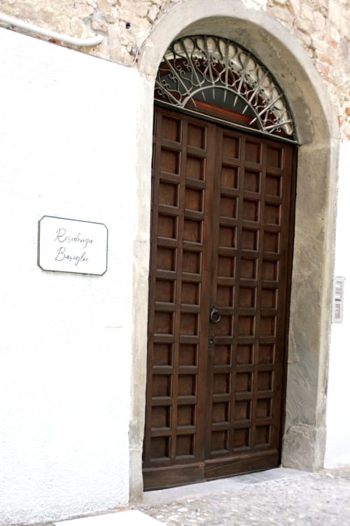 Elegante porta ad arco in legno antico con vetrata decorativa alla Residenza Basiglio, boutique bed and breakfast a Ceva, Italia