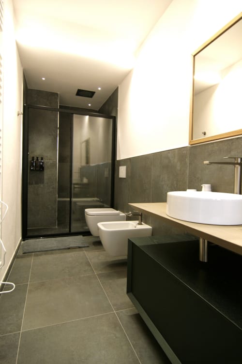 Bagno moderno a Residenza Basiglio con piastrelle scure, doccia walk-in, doppio lavabo e scaldasalviette