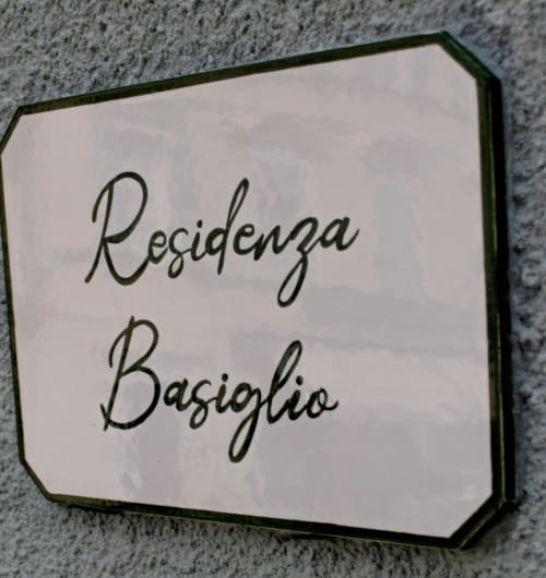 Targhetta della Residenza Basiglio su parete texture presso il bed and breakfast Ceva
