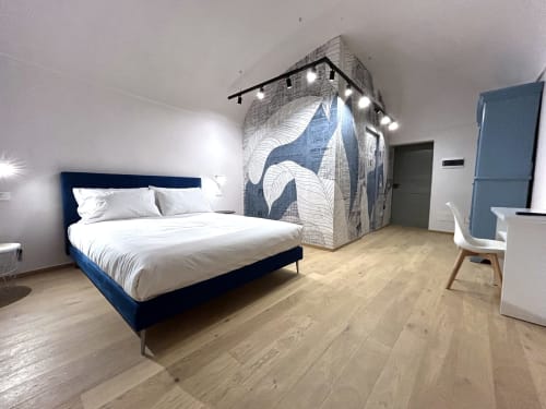 Camera moderna alla Residenza Basiglio di Ceva con letto blu, pavimenti in legno e installazione artistica murale
