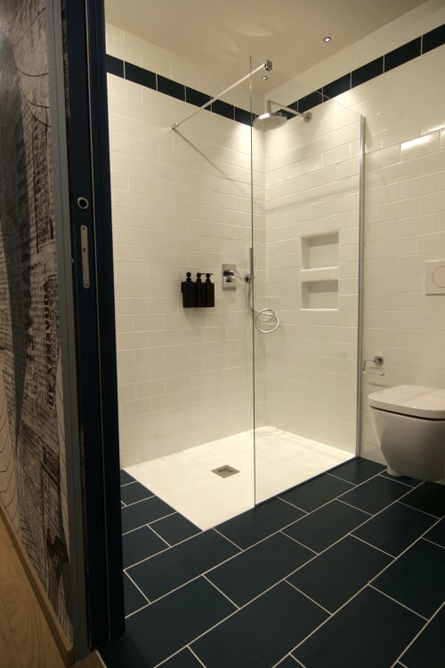 Bagno moderno con doccia walk-in, piastrelle bianche a spina di pesce e pavimento nero scuro a Residenza Basiglio, Ceva