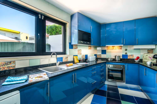 Cozinha moderna azul na Villa Odyssey em Albufeira com vista para o mar, eletrodomésticos em aço inoxidável